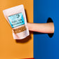Hand holding a package of 'Mighty Tasty Granola' against a colorful background