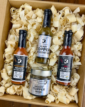 Box of Butterfly Bakery of Vermont Heady Topper hot sauces and mustard with wood shavings