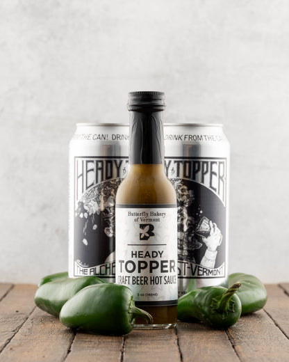 Bottle of Butterfly Bakery of Vermont Heady Topper Hot Sauce next to cans of Heady Topper beer and jalapenos