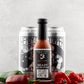 Bottle of Butterfly Bakery of Vermont Red Heady Hot Sauce next to cans of Heady Topper beer, jalapenos and ghost peppers