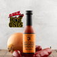 Bottle of Butterfly Bakery of Vermont Maple Wood Smoked Onion Hot Sauce on a wood surface with an onion and jalapeno peppers, with the 'As Seen On Hot Ones' logo