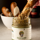A hand dipping a soft pretzel stick into a jar of Gustard Mustard from Butterfly Bakery of Vermont
