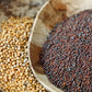 Two wooden bowls containing different types of mustard seeds