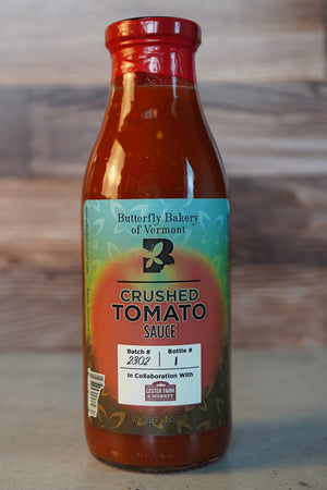 Bottle of Butterfly Bakery of Vermont Crushed Tomato Sauce against a wood background