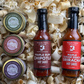 Two hot sauce bottles and three caramel jars in a box with wood shavings