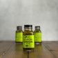 Bottle of Cilantro Onion hot sauce on a wooden surface with a gray background