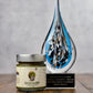 Jar of mustard and an award it won on a wooden surface with a gray background