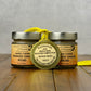 Two jars of Hard Cider Smoked Onion Mustard with a gold medal on a wooden surface.