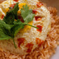Fried egg on top of Spanish rice and topped with hot sauce and parsley