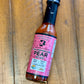 Bottle of Pink Peppercorn Pear hot sauce from Butterfly Bakery of Vermont on a wooden tabletop