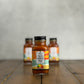 2oz bottle of 'Taco Vibes Only' sauce on a wooden surface with a gray background