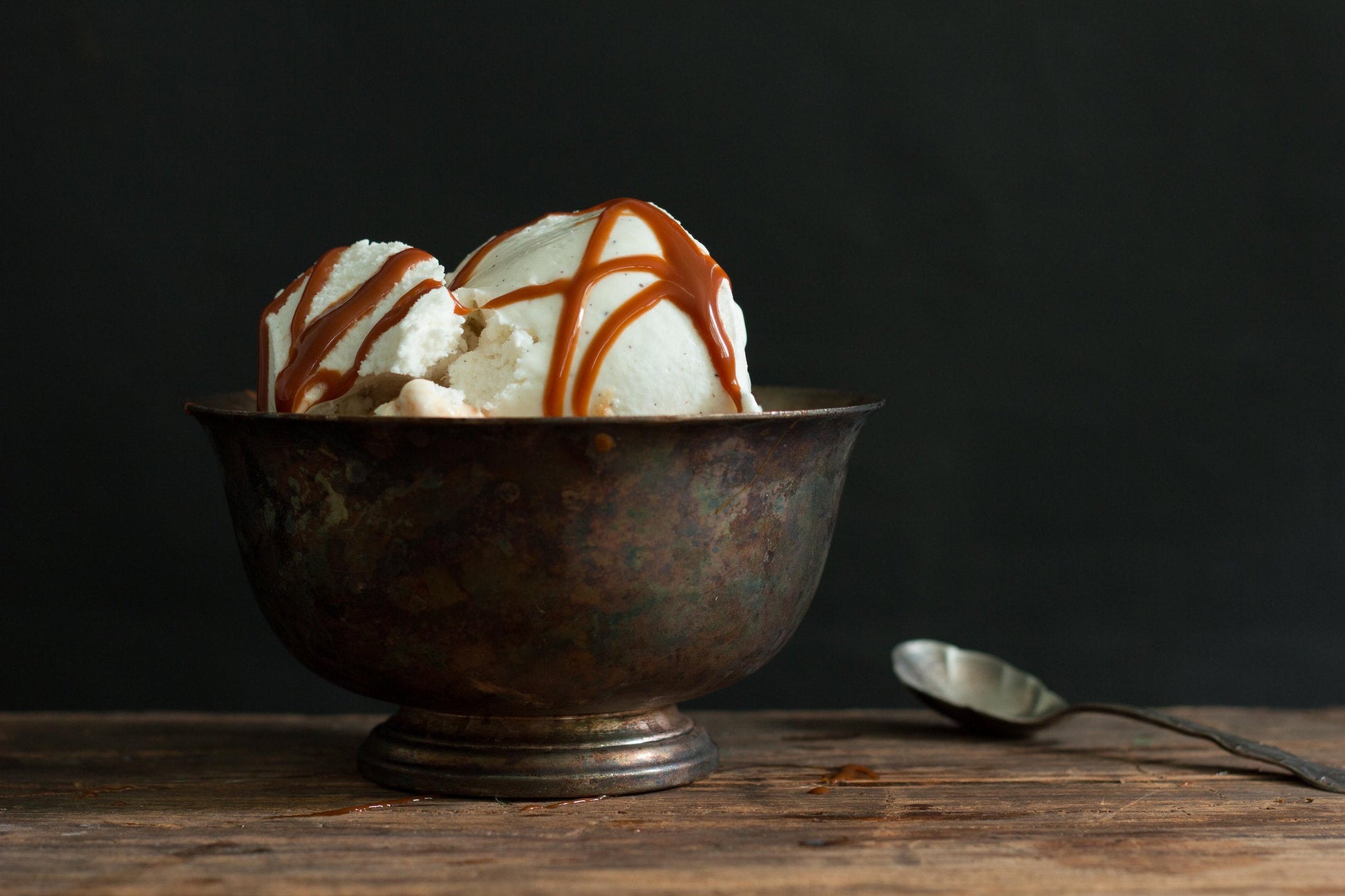 Metal bowl of vanilla ice cream drizzled with Fat Toad Farm caramel